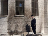 Palestinian Greek Orthodox priest George Awad checks the damage at the wall of a Greek Orthodox church hit by a firebomb in the West Bank city of Nablus, Saturday Sept. 16, 2006. (AP/ Majdi Mohammed) 